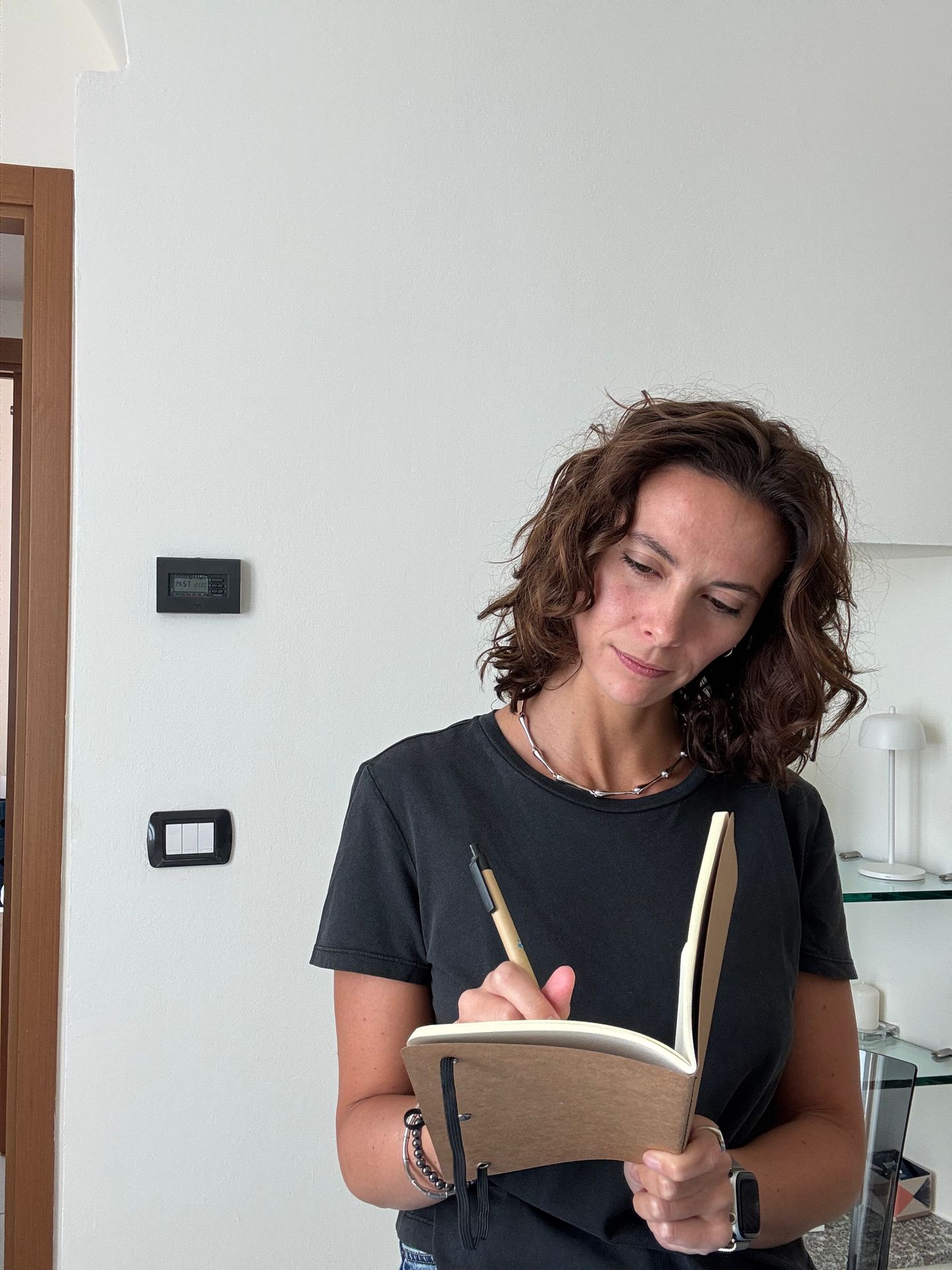 Silvia Barberis, in piedi nello studio, scrive su un quaderno.